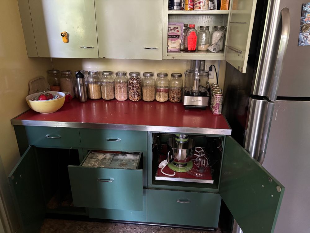 Baling station in a vintage-style kitchen showing built-ins for flour and a stand mixer. 