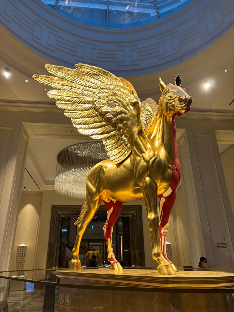 Damian Hirst “Legend” life size bronze cast painted horse; half in gold leaf, have exposed musculature. With wings!