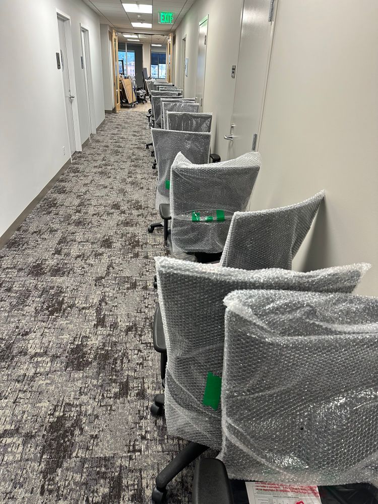A row of new office chairs ready to be moved into an office 