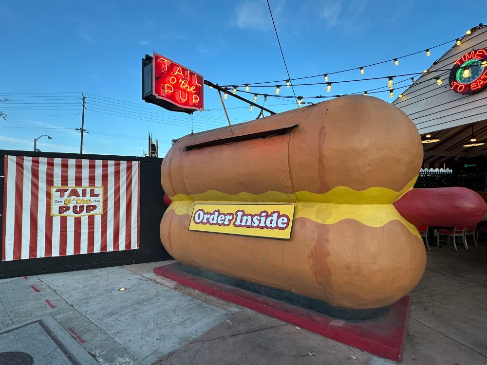 Tail of the Pup’s classic hot dog shaped stand they used to sell their hot dogs out of with a sign that says to order inside posted on it.