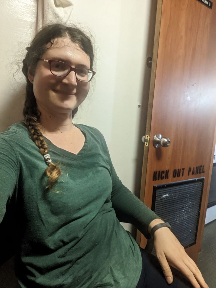 Photo of me in same position, after doing a quick back single braid to secure my hair for deck work 