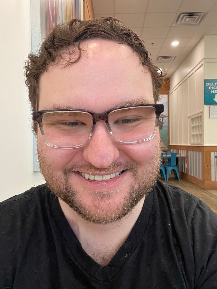 Selfie of man smiling in ombré black and clear rectangular glasses