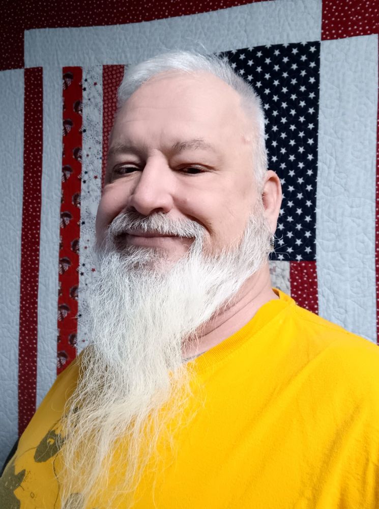 old fellow -grey beard and hair - wearing an orange shirt