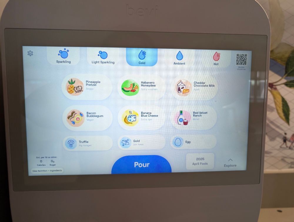 a beverage dispenser showing some strange flavors:
1. pineapple pretzel (soggy)
2. habanero [sic] honeydew (spicy mayhem)
3. cheddar chocolate milk (aged)
4. bacon bubblegum (vegan)
5. banana blue cheese (extra ripe)
6. red velvet ranch (moist)

and some strange options:
1. truffle (pig-foraged)
2. gold (24K flakes)
3. egg

and a button at the bottom reading "2025 April Fools".