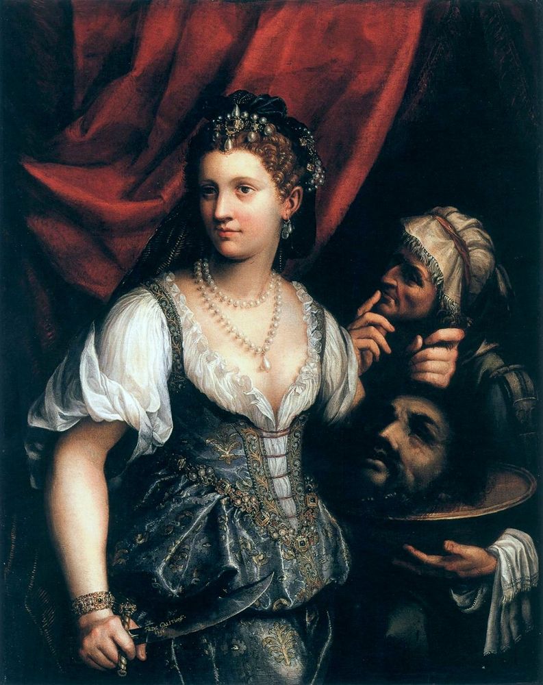 Fede Galizia's Judith with the Head of Holofernes, 1596; two white women stand before a red drapery. The woman in the foreground (Judith) has rosy cheeks , a straight nose, and brown eyes. She wears a dark velvet cap trimmed in pearls over her wavy auburn hair, and two strands of pearls around her neck. Her dress is blue and gold brocade over a translucent white blouse. She holds the head of a bearded man (Holofernes) by the hair. Her older handmaid, supports the head, which is no longer attached to his body, from beneath, using a metal tray. The handmaid, gazing at Judith from the shadows, stands with the first finger of the hand not holding the tray to her lips. I use a closeup of the handmaid for my profile pic.    