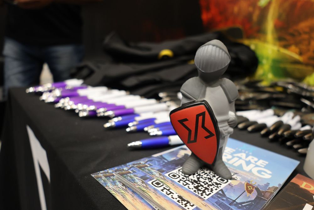 A figurine of a knight, standing in front of Jagex branded pens