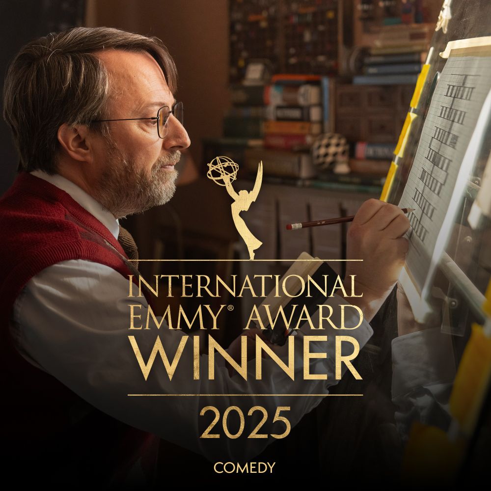 Image of David Mitchell designing a crossword in the show Ludwig. Overlaid is the Emmy logo, with text reading, 'International Emmy Award Winner 2025, Comedy'.