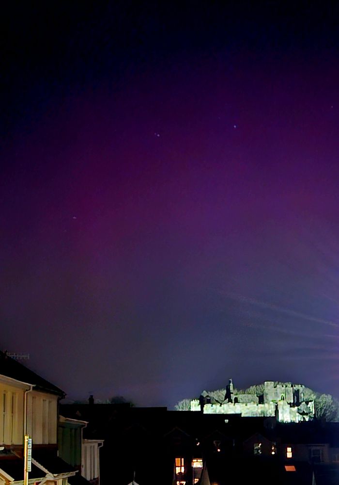 A purple sky of the Aurora borealis above Oystermouth Castle in Mumbles, Swansea