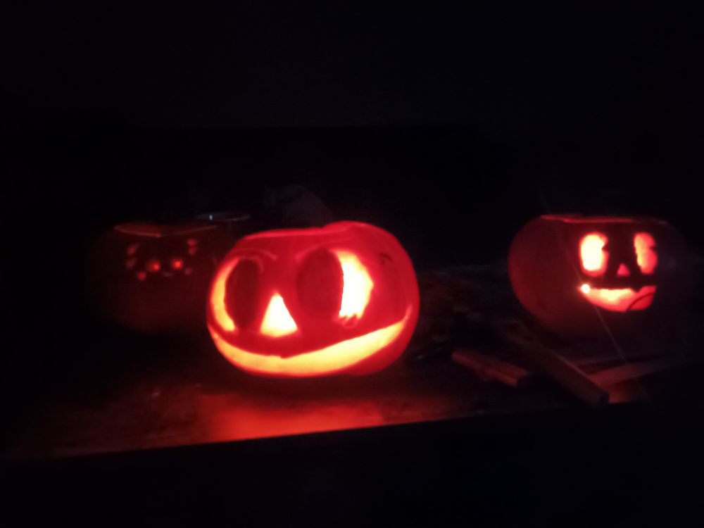 Three funky little pumpkins. One with a tiny face, the other with a big mischievous grin and the third who's really cute.