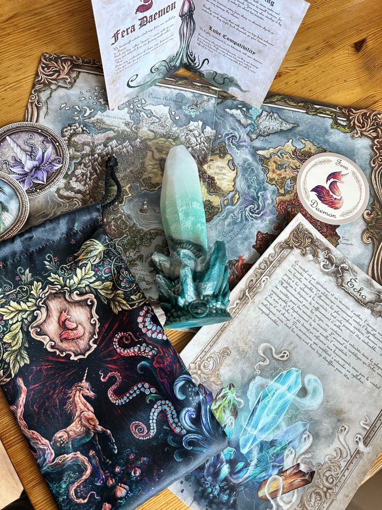Flat lay photo of Echo dildo by Fera Dameon with the accompanying art work & lore, storage bag, storage tin, stickers and care instructions 

Check out www.fera-daemon.com to shop their selection of handcrafted dildos

#gifted