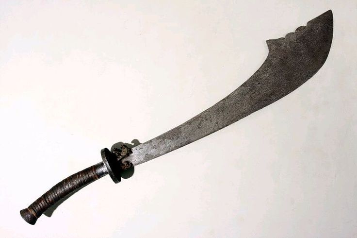 An antique cloud headed sword, with dark handle and a long curved blade that closely resembles the above fossil image