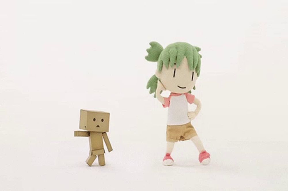 a girl with green hair is standing next to a cardboard box figure