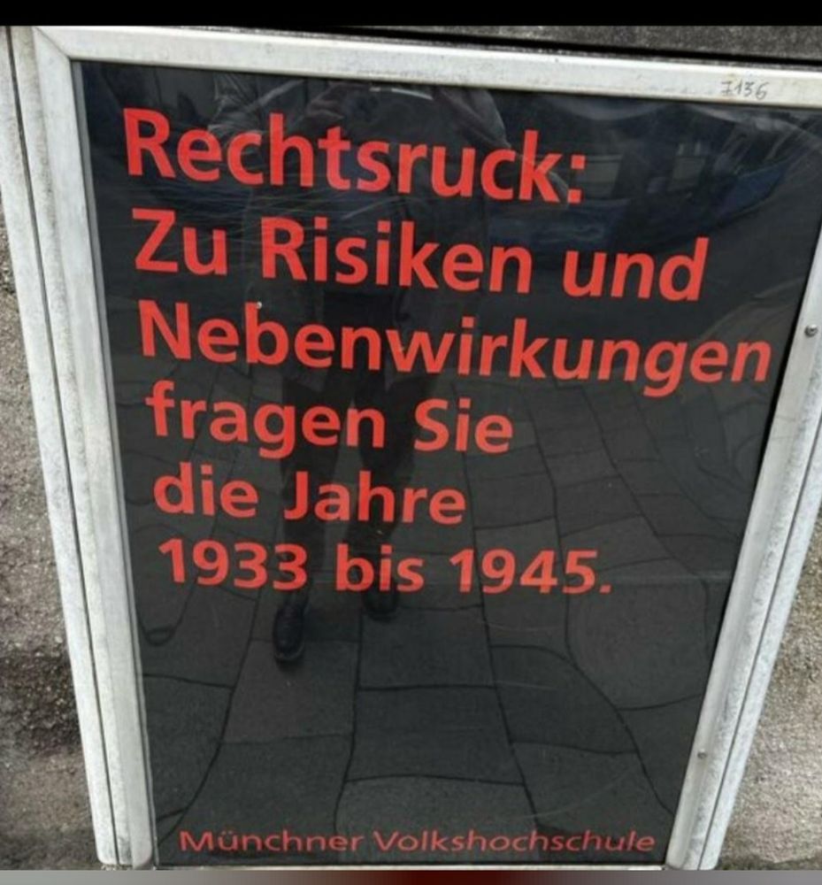 Foto eines Plakats der Münchener Volkshochschule, Schrift rot auf schwarz: "Zu Risiken und Nebenwirkungen fragen Sie die Jahre 1933-1945"