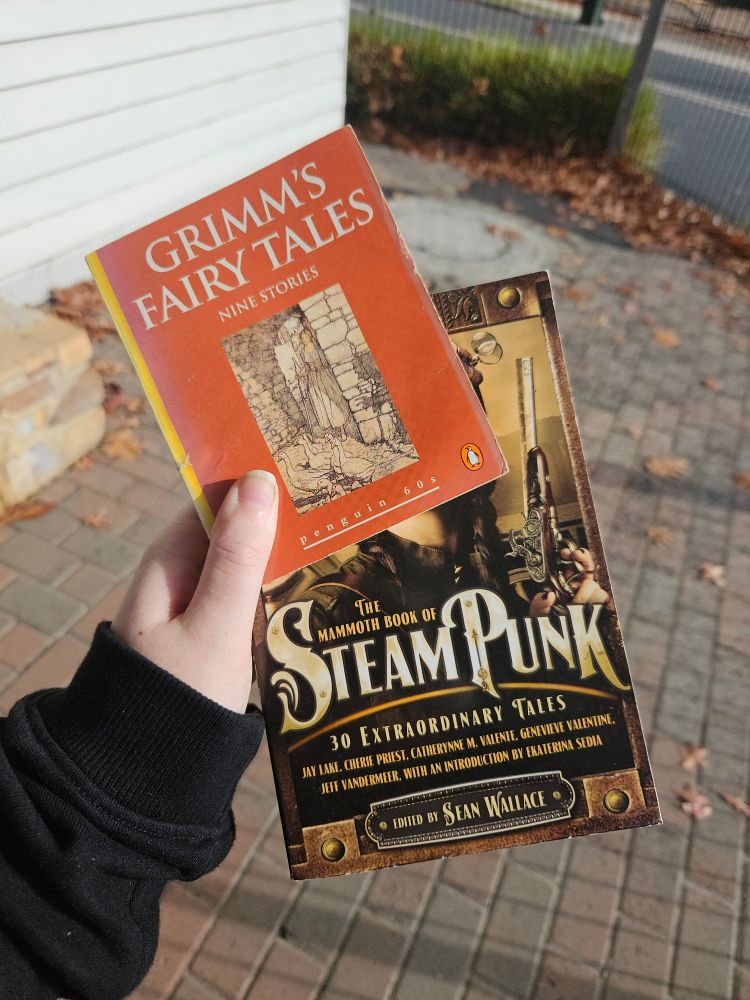 two books, one is a small penguins book of grimm's fairytales while the other one is 'the mammoth book of steampunk'
