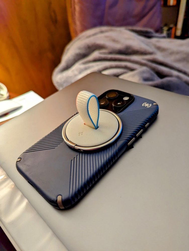 Spigen O-Mag MagSafe holder attached to an iPhone 
