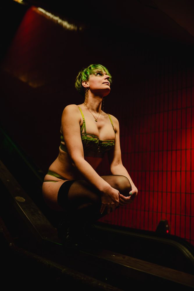 Bild von mir in Dessous in Hocke auf einem Geländer zwischen Rolltreppen in einer U-Bahn Station