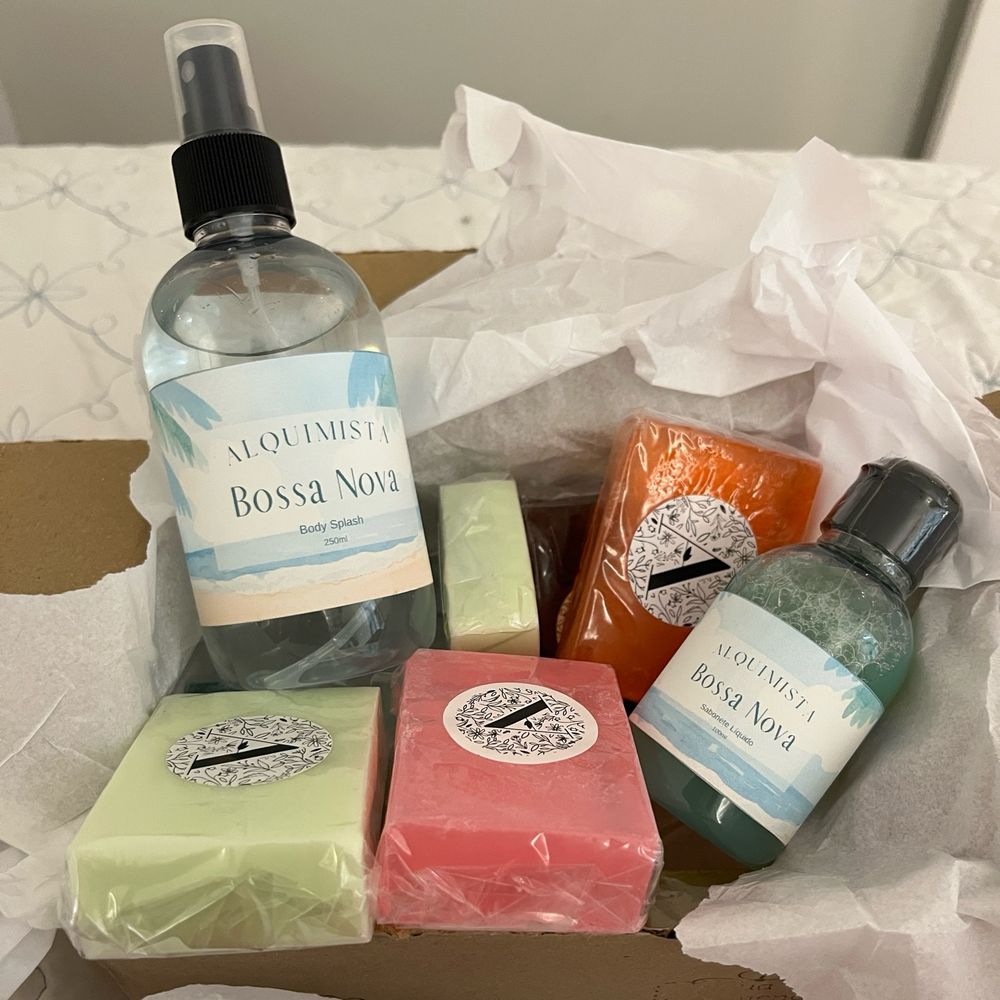 Foto de uma caixa com sabonetes em barra, sabonete líquido e body splash da marca Alquimista.
