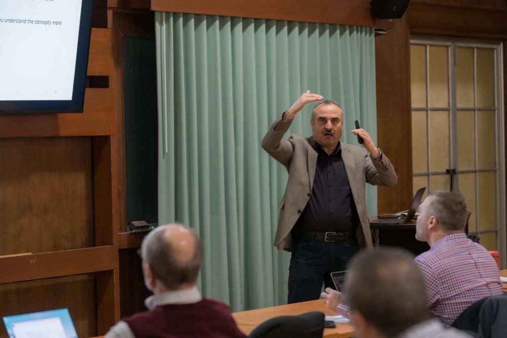 Nimer Murshid stands at the front of a classroom and talks to other professors.
