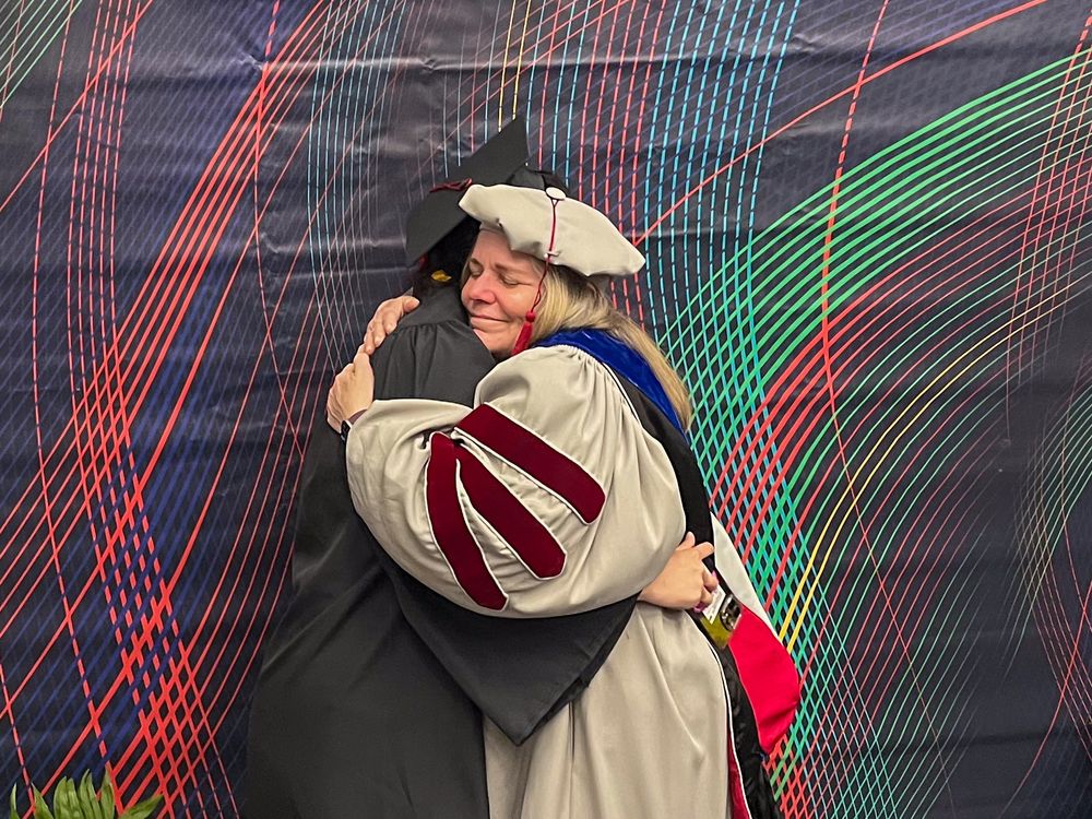 Glen de Vries Dean of the Mellon College of Science Barbara Shinn-Cunningham hugs graduating physics student Yunshu Li.
