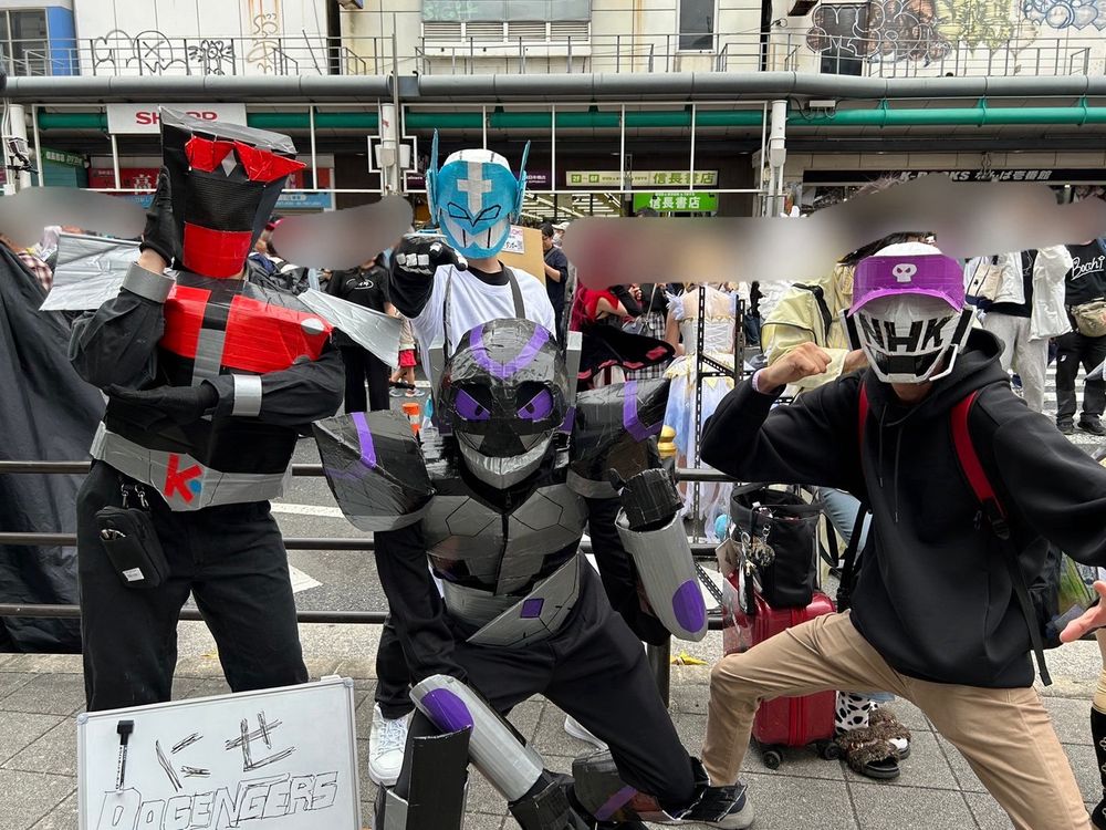 ドゲンジャーズという福岡県のローカルヒーローのコスプレ。だが、敢えて段ボールで雑に作り、「にせドゲンジャーズ」というコンセプトで制作。写真右側にはシャベリーマンという悪役の偽者、画面中央手前にはヤバイ仮面という悪役の偽者、ヤバイ仮面の後ろにオーガマンという薬局のヒーローの偽者、画面左側にキタキュウマンという北九州市のローカルヒーローの偽者が立っている。
にせキタキュウマンの足元にはホワイトボードが置いてあり「にせDGENGERS（ドゲンジャーズ）」と書かれている。