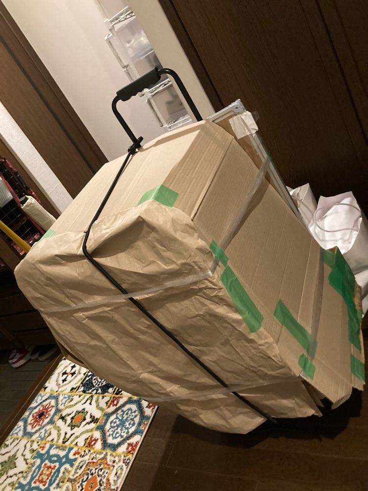 2024年5月12日(日)に大阪日本橋で開催される日本橋ストリートフェスタ2024のために準備された荷物が写っている。
運ぶ物が大きいため通常の段ボールには入らず、段ボールをカットして繋ぎ合わせたもので対象を囲っている。また、運搬しやすいようにキャリーに乗せてある。