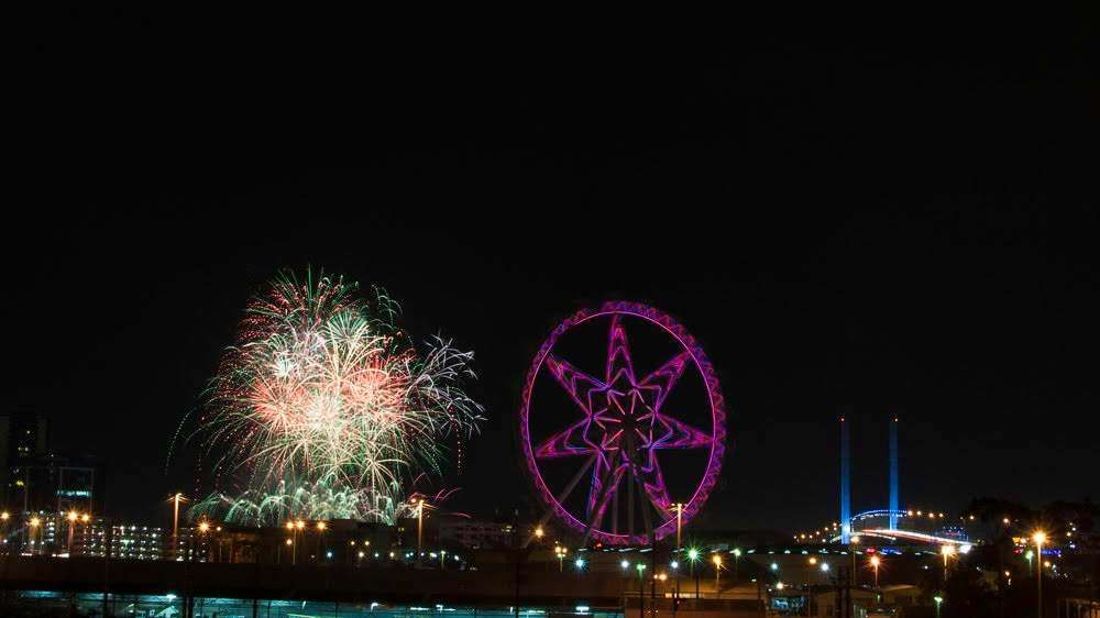 The Melbourne Star observation wheel with the twin pylons of the Bolte Bridge to the right and fireworks to the left.