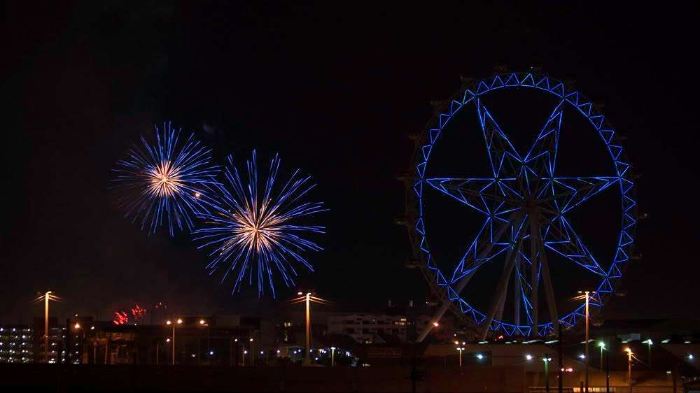 The Melbourne Star observation wheel at night with fireworks in the background.
