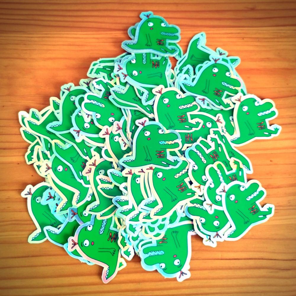 Un tas de stickers représentant un dinosaure illustré de ma main. Ce dinosaure n'est pas très réaliste mais néanmoins très mignon à mon humble avis.