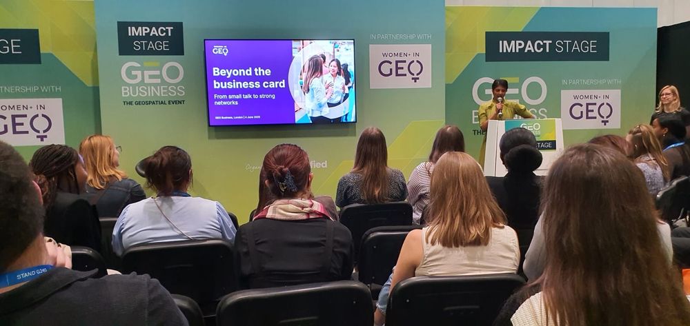 A person from Women in Geospatial+ presenting a talk called "Beyond the business card - from small talk to strong networks".