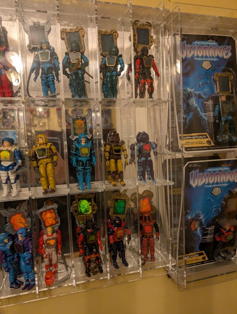 Photograph of loose Visionaries Knights of the Magical Light toys in a custom display case with mirrored background owned by the Mapes Brothers, David and Steven Mapes
