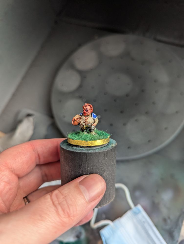 A 30mm scale Blood Bowl miniature. This is a Halfling holding a football with a pretty hefty bruise on his eye and a blood nose.