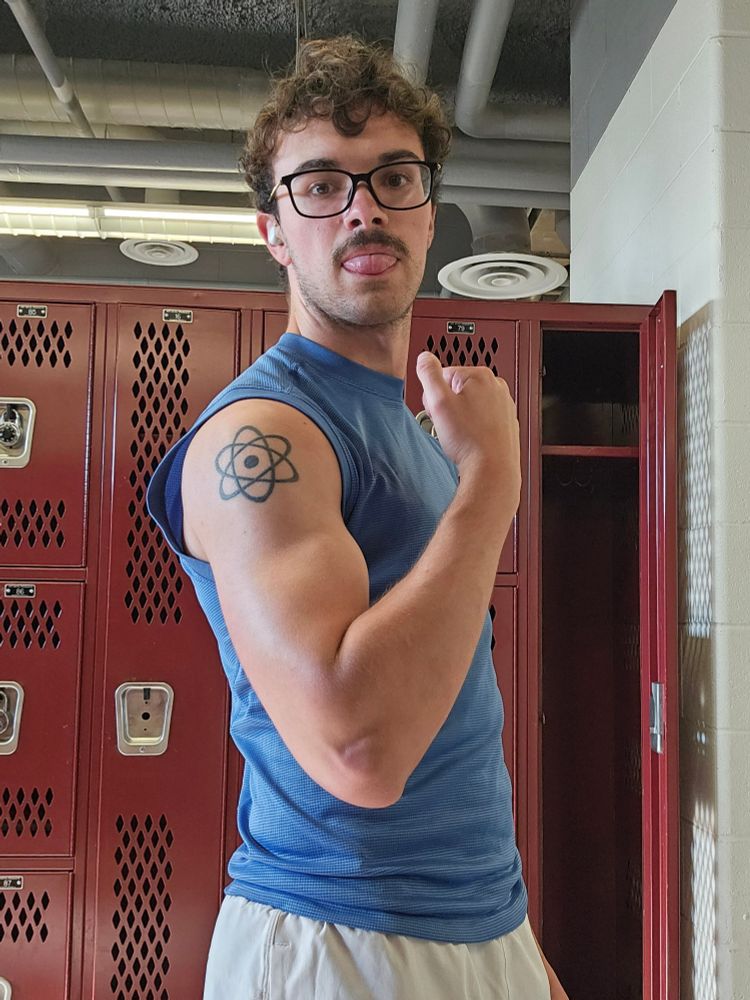 Selfie of me in the gym lockerroom flexing my arm. Idk what my face is doing. There is no goo present in the picture.