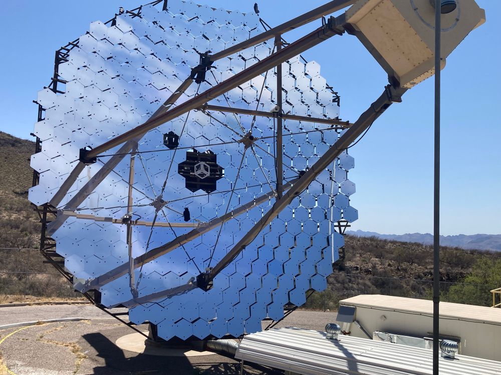 Crow perched on segmented telescope mirror of VERITAS