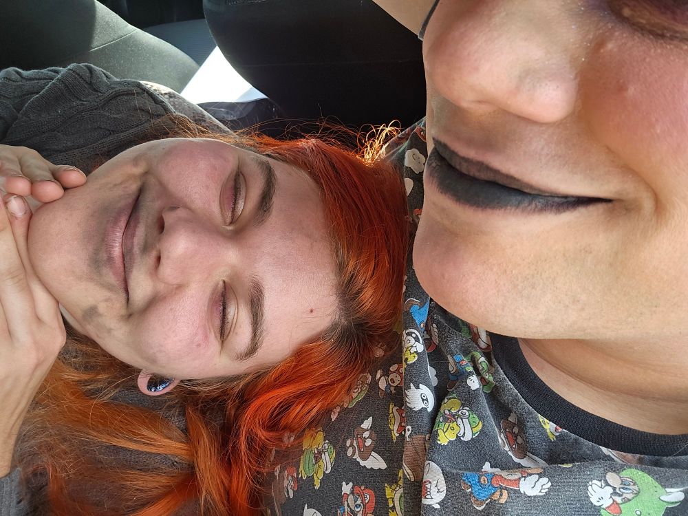 A girl and her Bf with kiss marks all over his face while he smiles