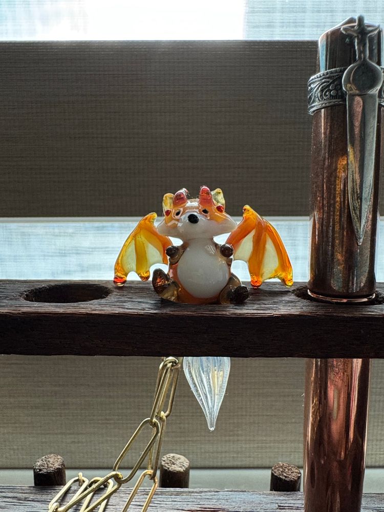 Glass winged fox dip pen pendant by Glassophy beside a copper fountain pen 