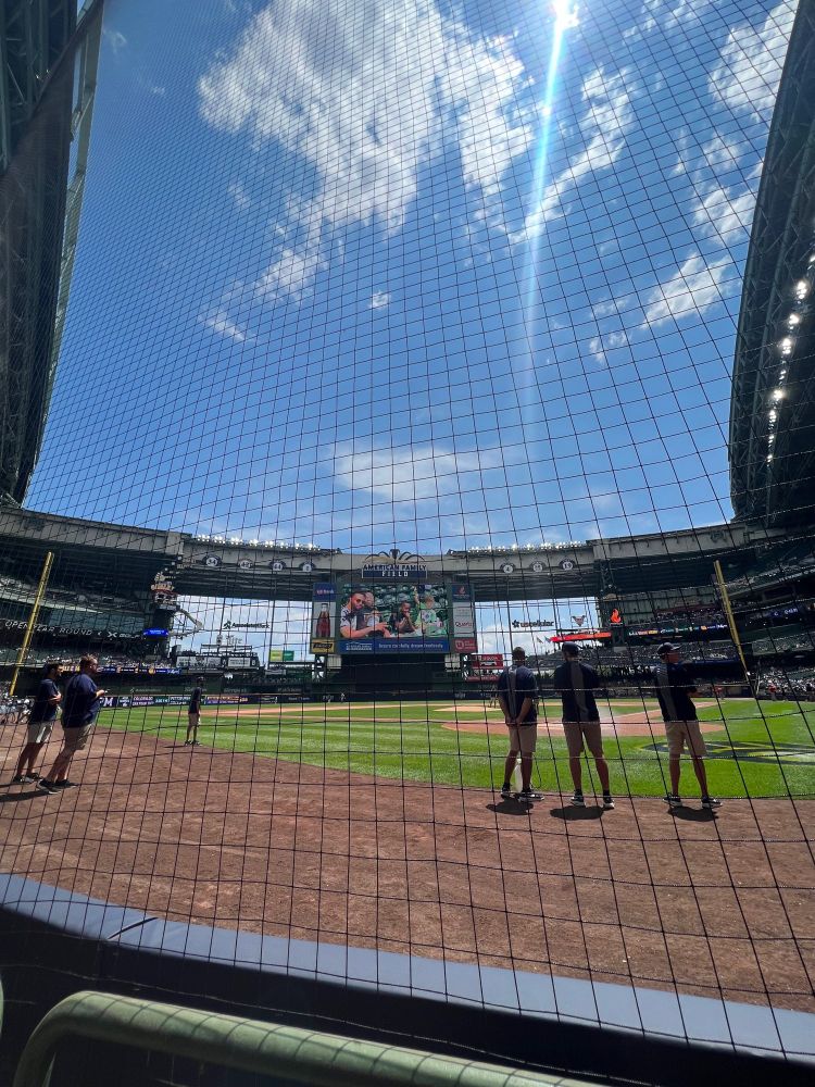 A view of Miller Park from behind home plate. A few clouds in the sky but very very sunny. 
