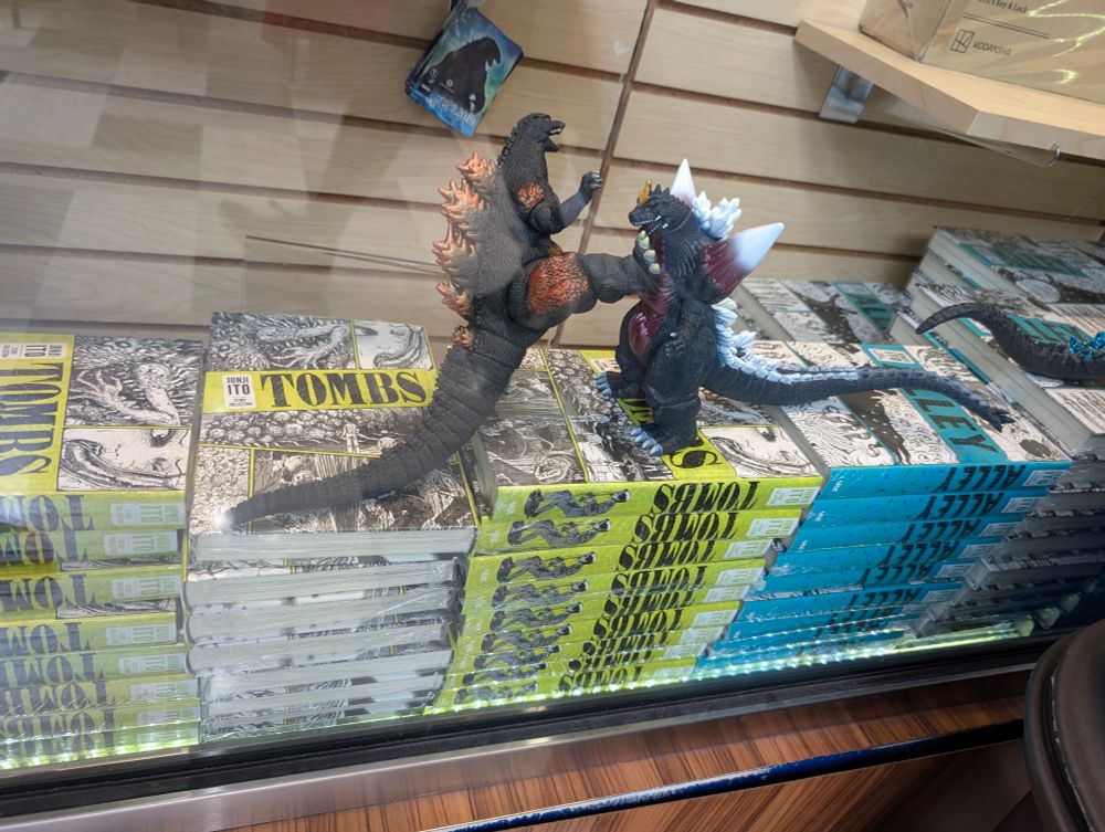 Burning Godzilla figure kicks Space Godzilla figure in bookstore window display