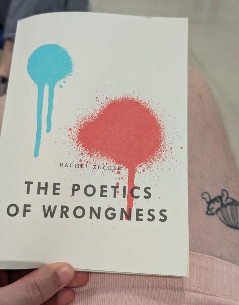 A photo which shows me holding The Poetics of Wrongness by Rachel Zucker. 