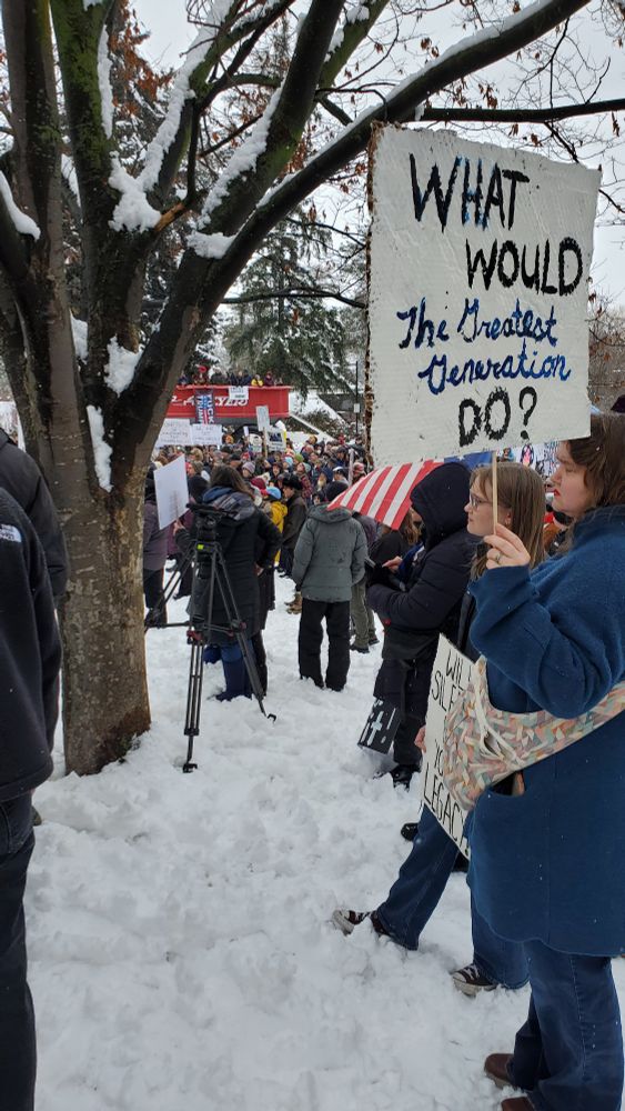 Protest Rally in Spokane Washington. Woman holds sign that says "What would the greatest generation do?"