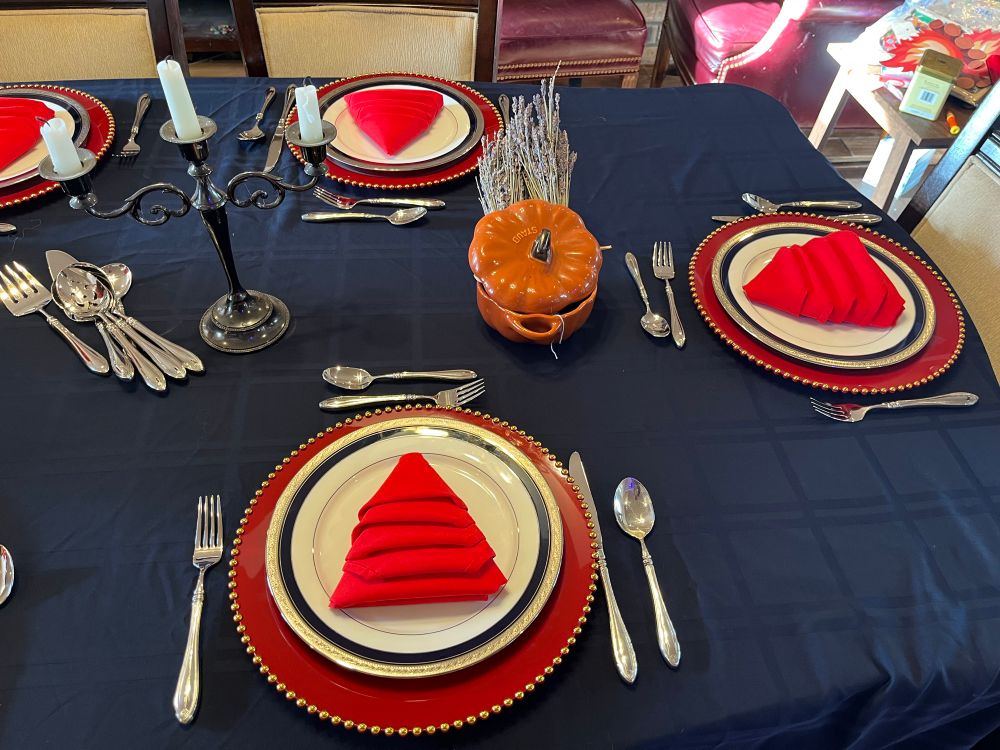 A close up of the place settings. The red napkins are folded like Christmas trees