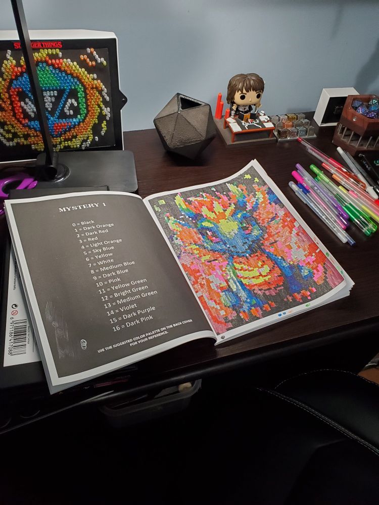 Photo of a color by numbers coloring book page of a young dragon 