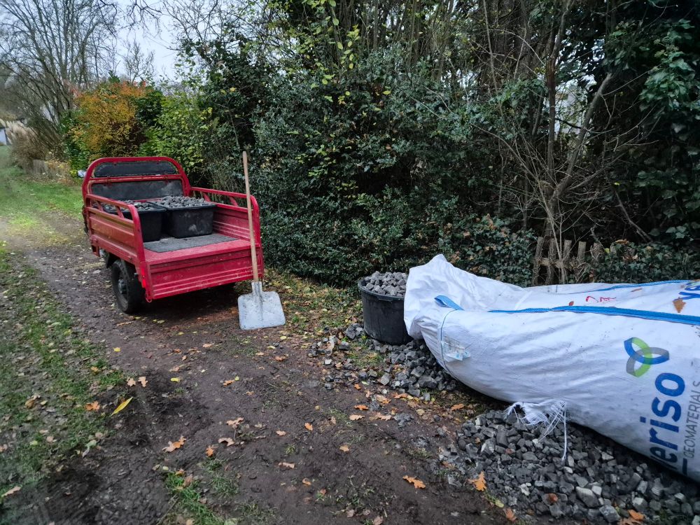 Tuktuk und ein großer Kübel, der am noch größeren Bigbag mit Schaumglasschotter befüllt wird