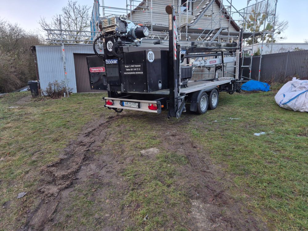 Großer Anhängerkran steht vorm Haus, er hat den Boden etwas kaputt gefahren