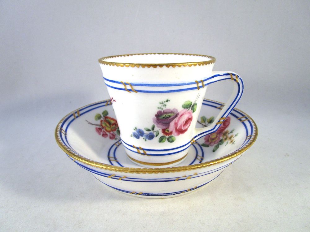 Diameter of cup: 2 13/16” (7.1 cm), 3 5/8” (9.1 cm) with handle, height 2 5/8” (6.6 cm). Diameter of saucer: 5 1/4” (13.3 cm), 1 1/4” deep (3.2 cm).
