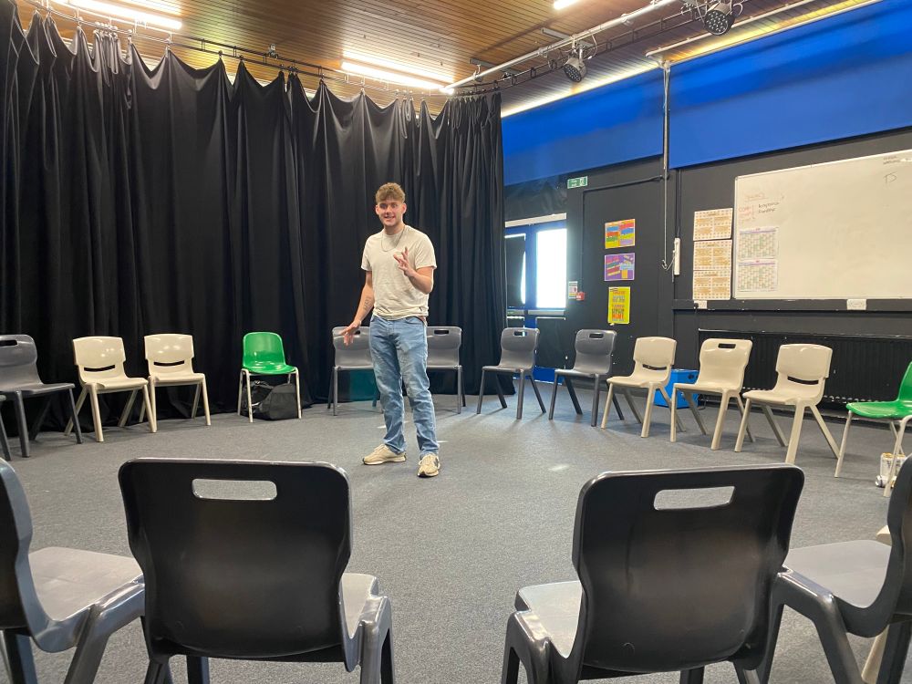 The Actor stands rehearsing in a circle of chairs. 