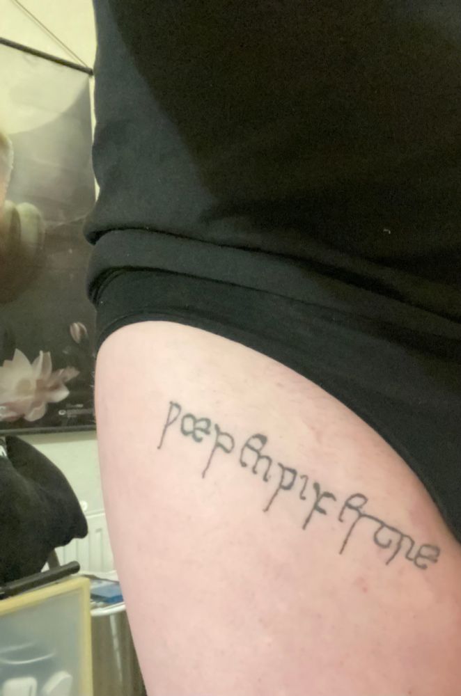 image of a tattoo on the upper right thigh that reads wæpenwifestre, in black ink, and in the insular hand of the Exeter Book