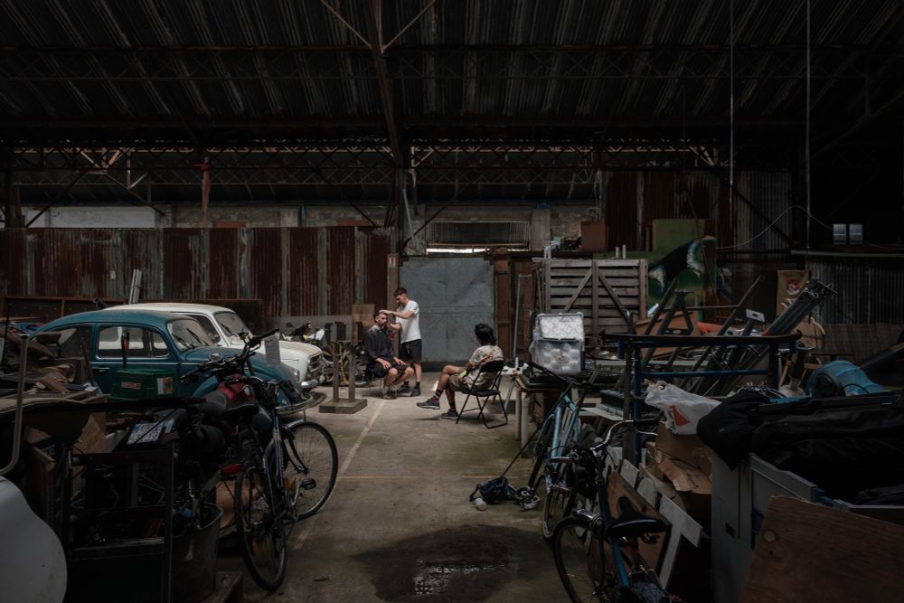 Personnes se faisant couper les cheveux dans un hangar lors d’un tournoi de bike polo