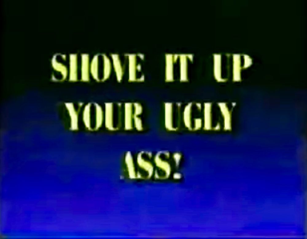 Screenshot from the infamous “Big Bill Hell’s Cars” commercial. Yellow text on a dark blue to light blue gradient, reading “Shove it up your ugly ass!”