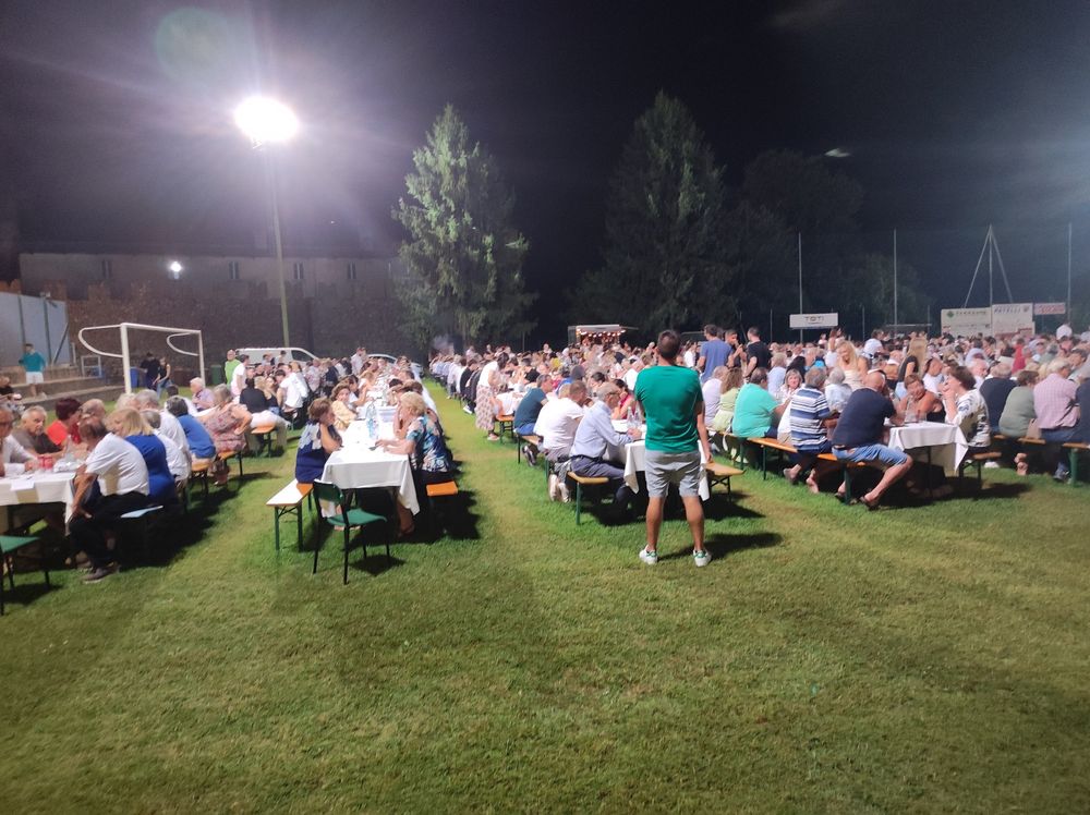 Il campo dell'oratorio pieno di tavoli e persone che attendono la tombola.
