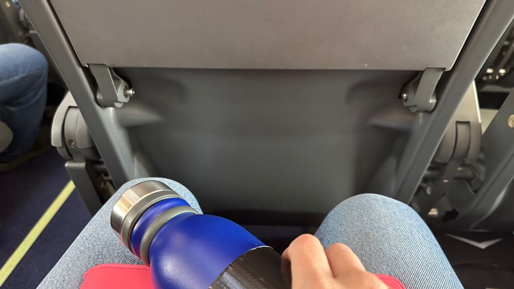 Back of plane seat with missing (mesh) bag for small items.